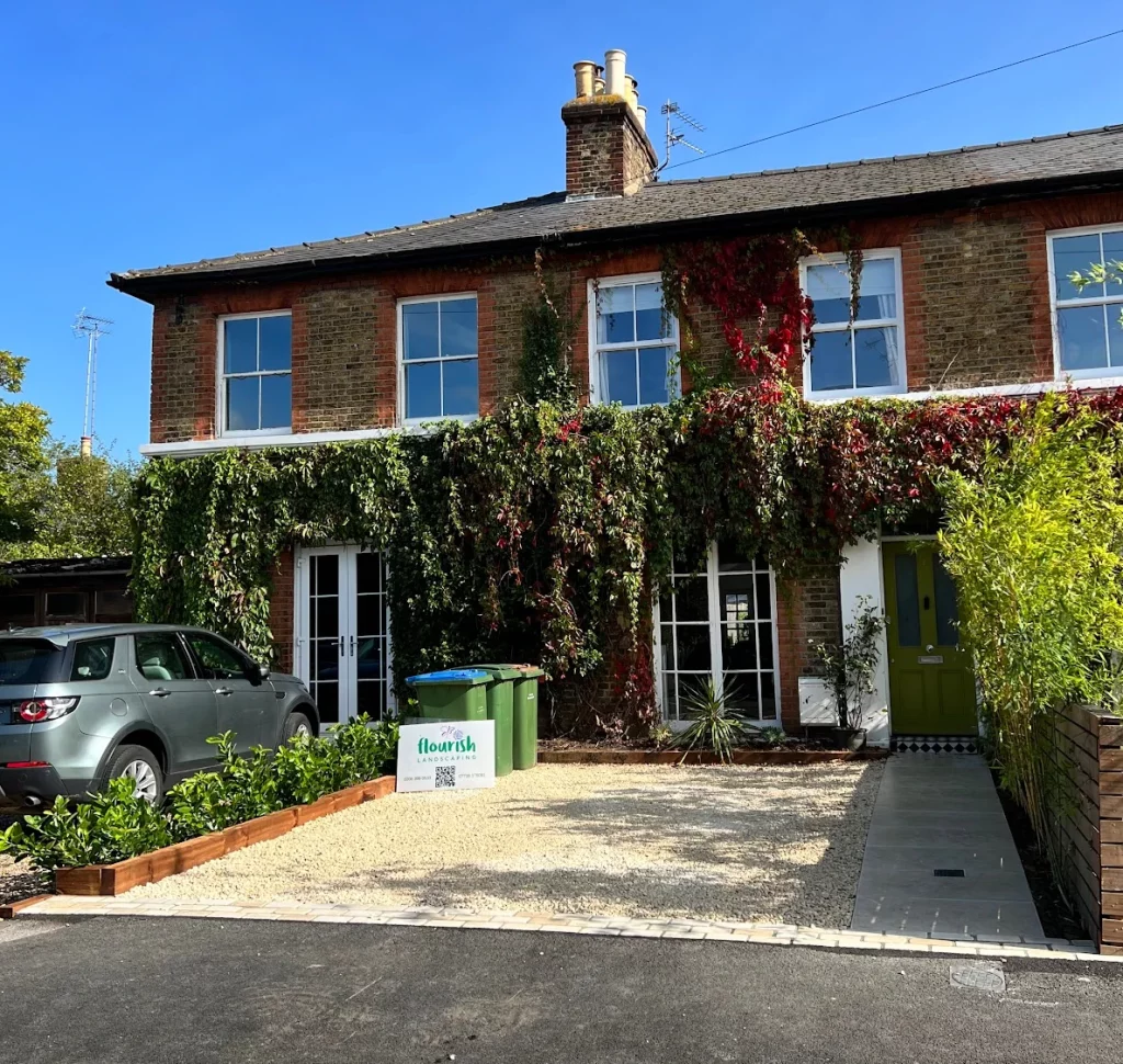 Driveway in Long Ditton with limestone paving, timber sleeper beds and gravel