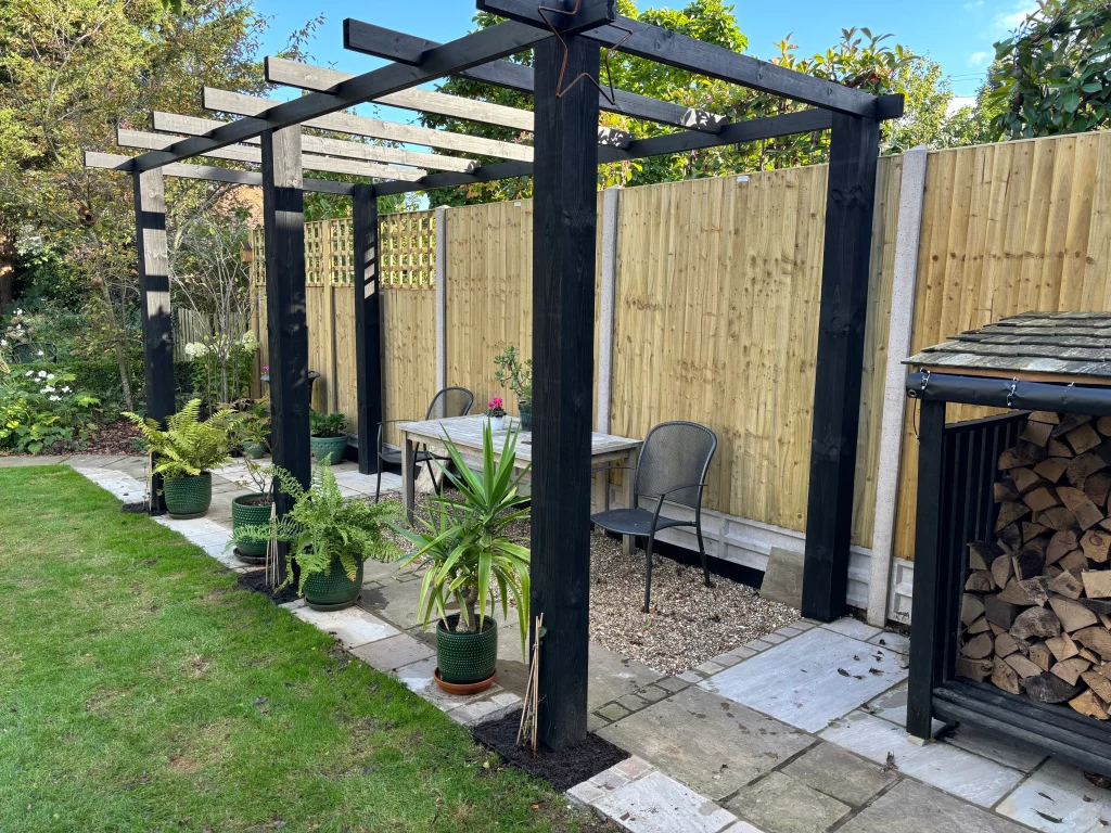 Timber pergola and paved seating area in a Weybridge garden